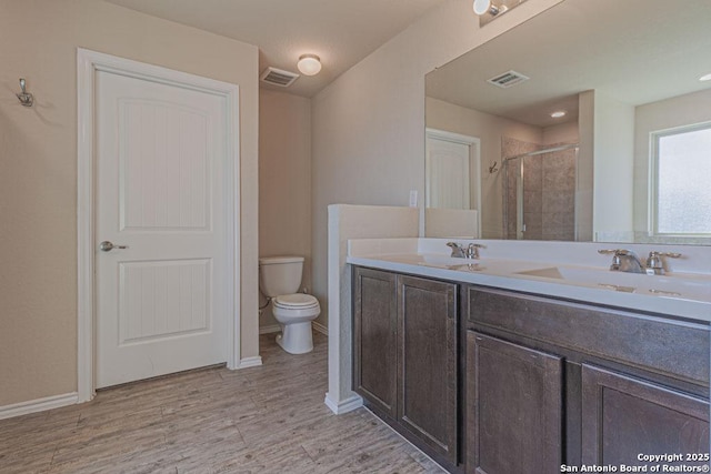 full bathroom with visible vents, toilet, wood finished floors, and a shower stall