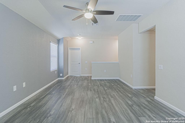 empty room featuring visible vents, baseboards, and wood finished floors