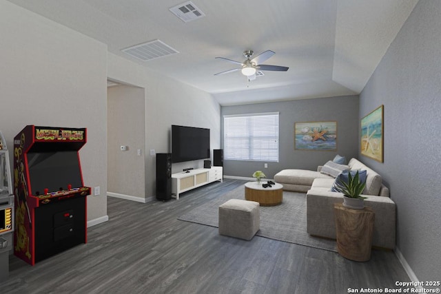 living area with visible vents, baseboards, dark wood-type flooring, and ceiling fan