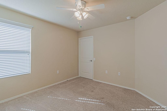 unfurnished room featuring baseboards, a ceiling fan, and carpet floors