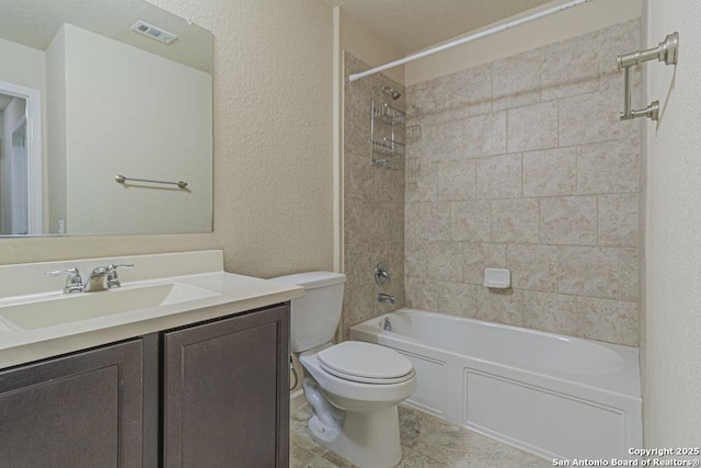 bathroom featuring visible vents, toilet, shower / bathtub combination, a textured wall, and vanity