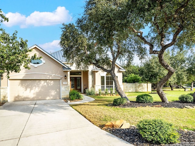 view of front of home featuring a front yard, fence, stucco siding, concrete driveway, and a garage