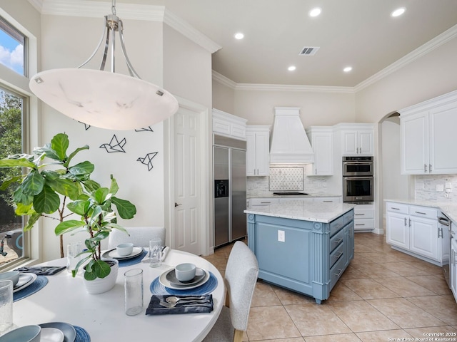 kitchen featuring visible vents, blue cabinetry, crown molding, appliances with stainless steel finishes, and white cabinets