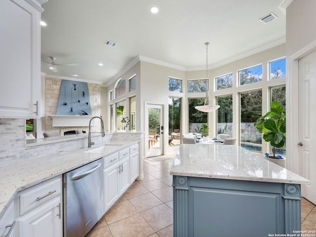 kitchen featuring visible vents, a sink, plenty of natural light, stainless steel dishwasher, and crown molding