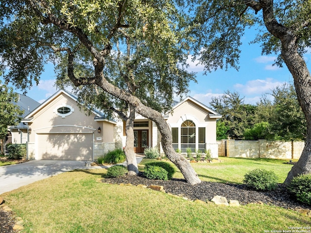 single story home featuring a front yard, fence, an attached garage, concrete driveway, and french doors