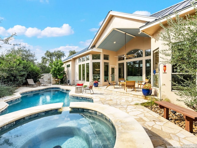 view of swimming pool featuring ceiling fan, a pool with connected hot tub, and a patio