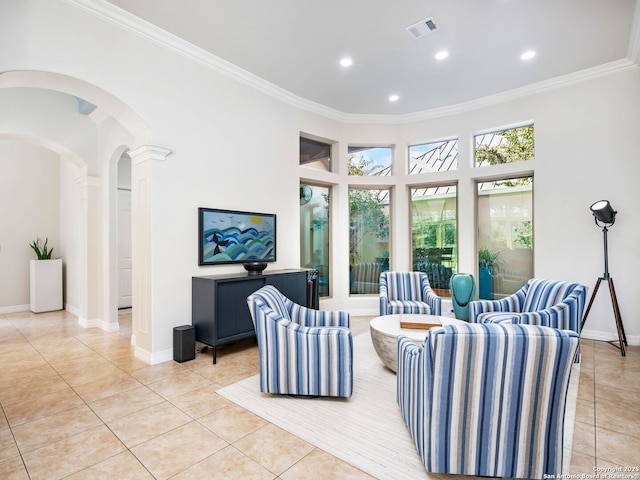 living room featuring light tile patterned flooring, baseboards, visible vents, and ornamental molding