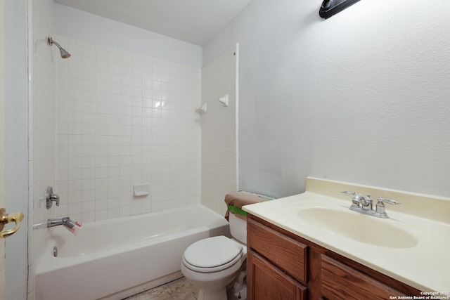 bathroom with vanity, toilet, shower / bath combination, and a textured wall