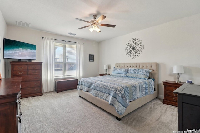 bedroom featuring ceiling fan, visible vents, and light carpet