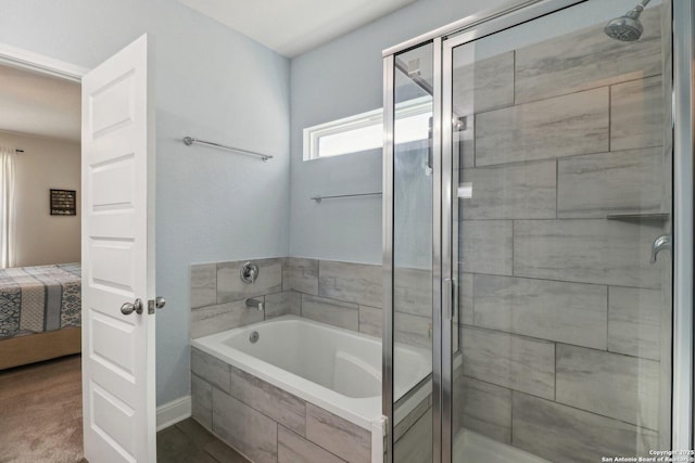 ensuite bathroom featuring connected bathroom, a stall shower, and a garden tub