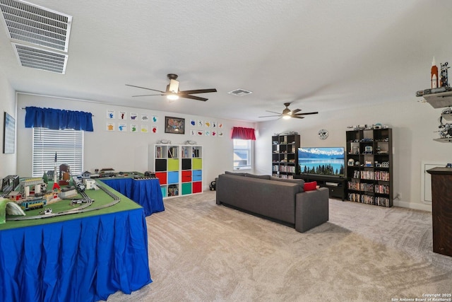 living room with a ceiling fan, carpet, and visible vents