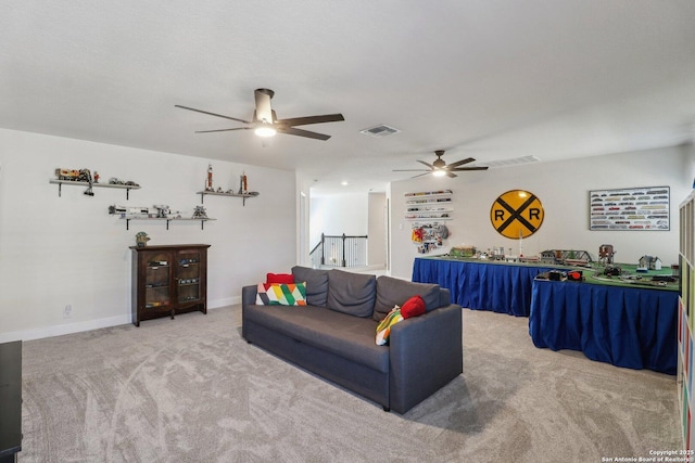 carpeted living area with visible vents, baseboards, and a ceiling fan