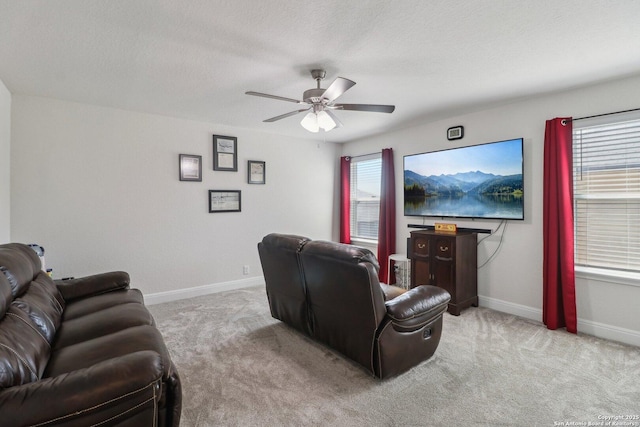 carpeted living room featuring baseboards, a textured ceiling, and ceiling fan