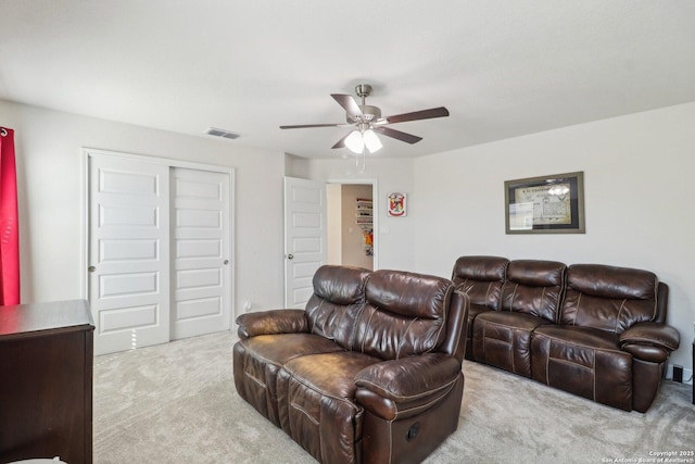 living area with visible vents, carpet floors, and ceiling fan