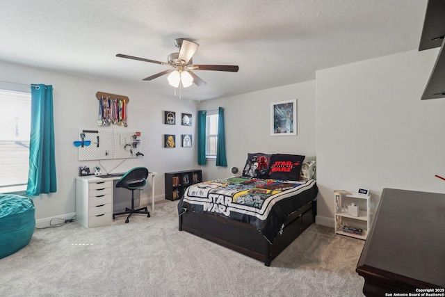 bedroom featuring baseboards, carpet floors, a textured ceiling, and ceiling fan