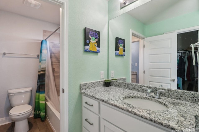 full bathroom featuring vanity, shower / bath combination with curtain, a spacious closet, and toilet