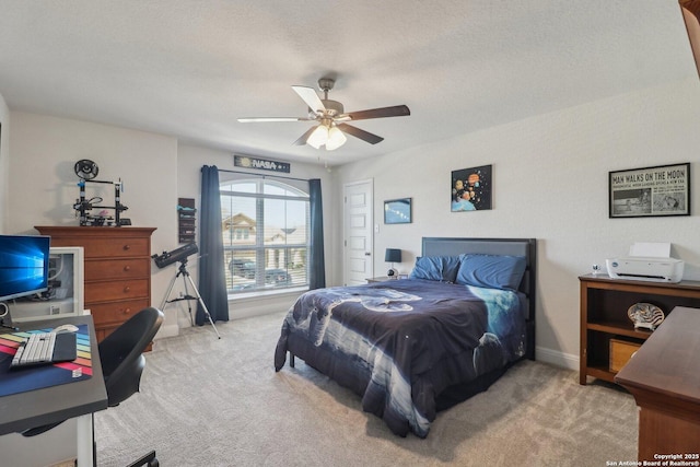 carpeted bedroom featuring baseboards, a textured ceiling, and a ceiling fan