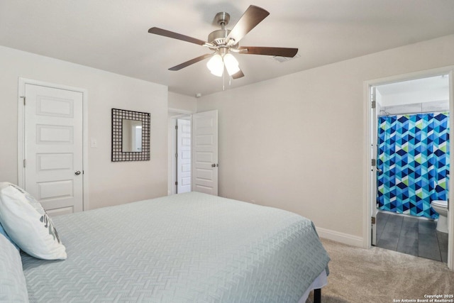 carpeted bedroom with connected bathroom, baseboards, and a ceiling fan