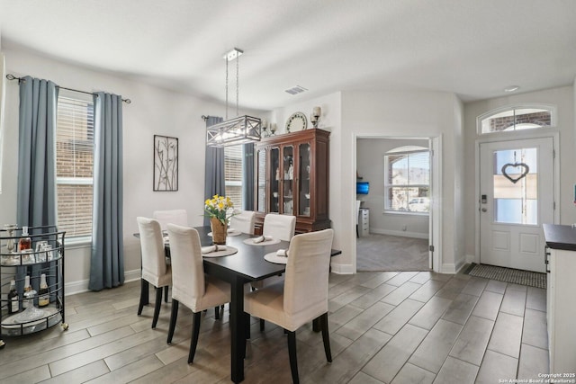 dining area with wood finish floors, visible vents, and baseboards