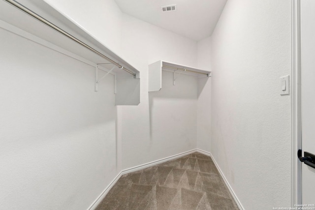 spacious closet with visible vents and dark carpet