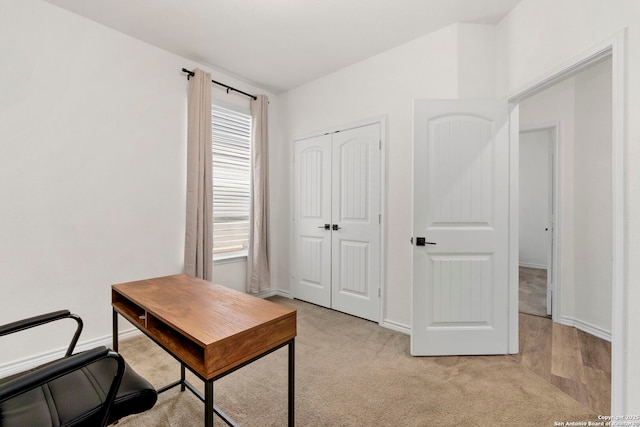 office featuring baseboards and light colored carpet