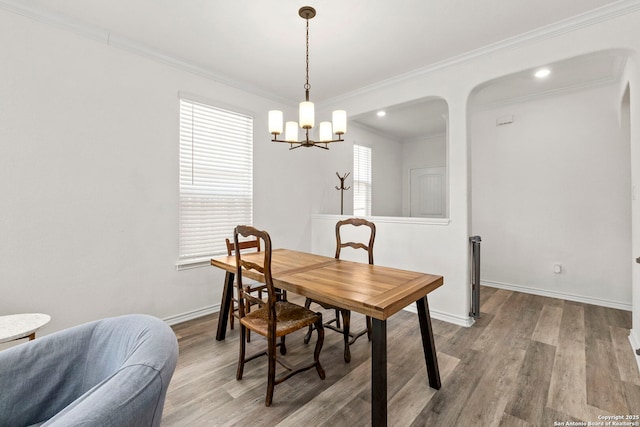 dining room featuring baseboards, wood finished floors, and ornamental molding