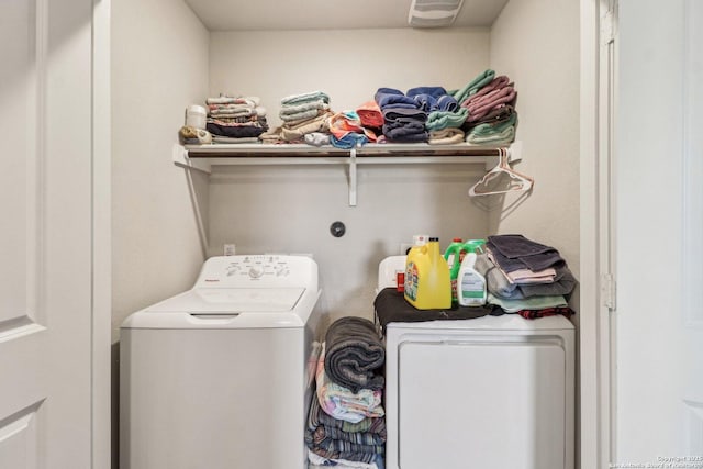 washroom with laundry area, separate washer and dryer, and visible vents