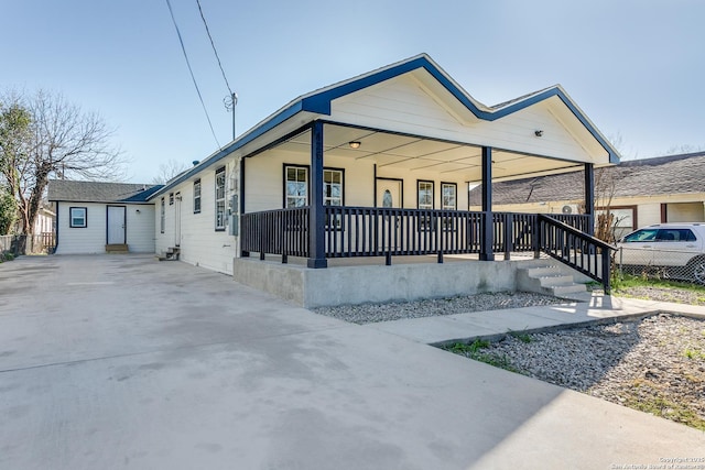 view of front of property featuring fence and covered porch