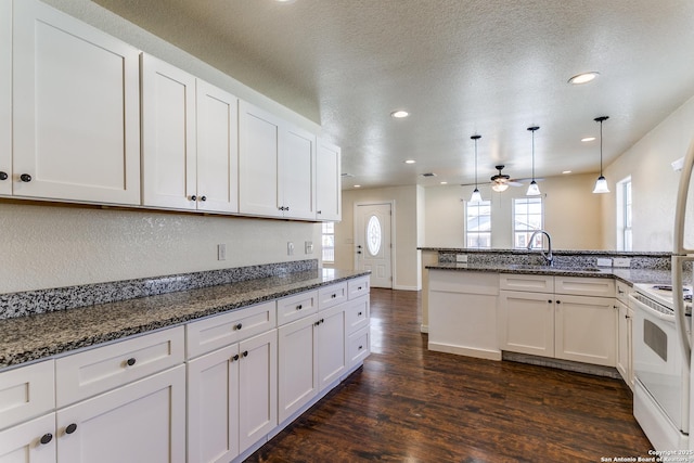 kitchen featuring white electric range, decorative light fixtures, a textured ceiling, dark wood-style floors, and white cabinets