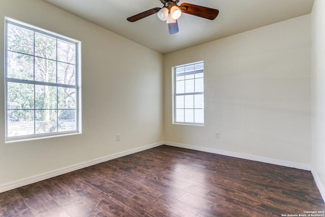 spare room featuring ceiling fan, dark wood-type flooring, and baseboards