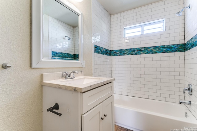 bathroom with vanity, a textured wall, and shower / washtub combination