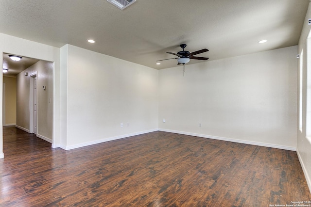 spare room with dark wood-type flooring, recessed lighting, visible vents, and baseboards