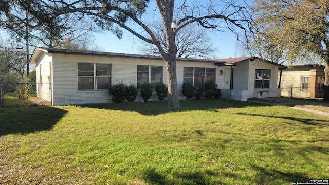 ranch-style home with brick siding, a front yard, and fence