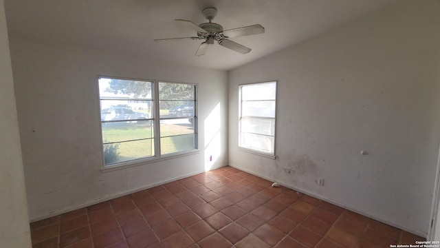 empty room with ceiling fan, tile patterned flooring, and vaulted ceiling