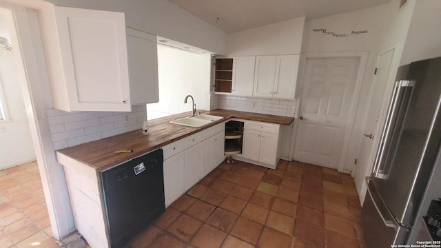 kitchen with a sink, open shelves, butcher block counters, and freestanding refrigerator