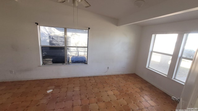 unfurnished room featuring tile patterned floors, baseboards, and lofted ceiling