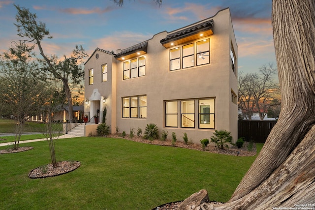 view of front facade featuring a front yard, fence, and stucco siding