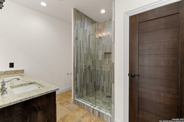 bathroom featuring a sink, baseboards, recessed lighting, and a shower stall