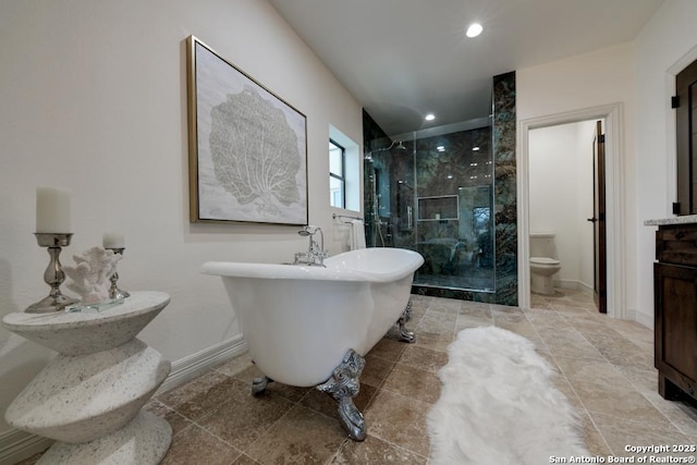 bathroom featuring baseboards, toilet, recessed lighting, a stall shower, and a freestanding tub