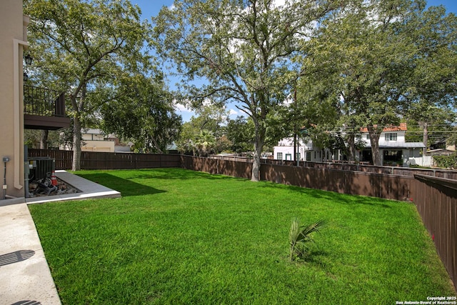 view of yard with central air condition unit and a fenced backyard