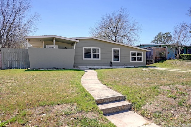 view of front of home with a front yard and fence