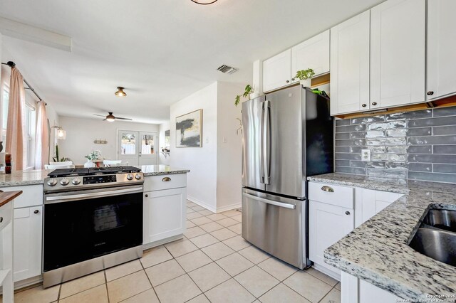 kitchen with visible vents, backsplash, stainless steel appliances, white cabinets, and light tile patterned flooring