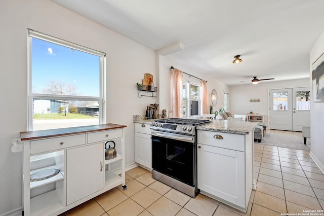 kitchen featuring a wealth of natural light, open floor plan, a peninsula, and stainless steel range with gas stovetop