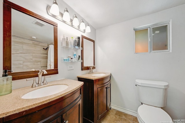 full bath featuring a sink, visible vents, toilet, and two vanities