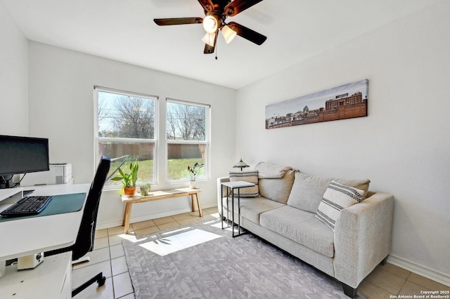 office space with light tile patterned floors, baseboards, and a ceiling fan