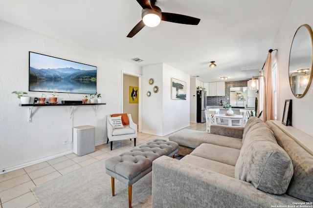 living area with light tile patterned floors, visible vents, baseboards, and ceiling fan