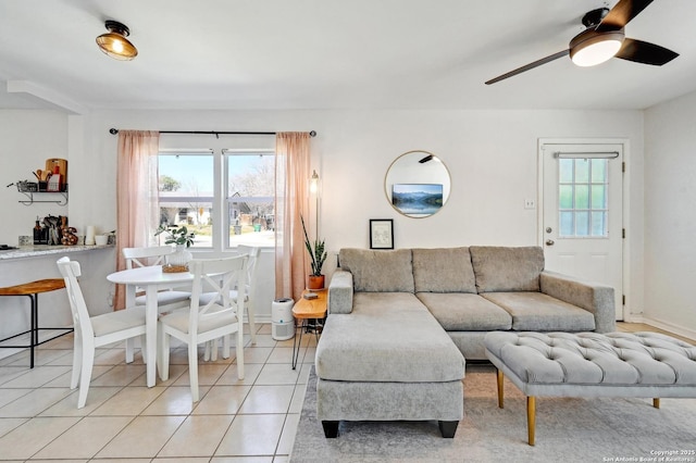 living area with a ceiling fan, light tile patterned flooring, and a healthy amount of sunlight