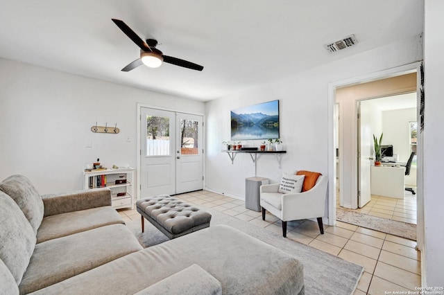 living area with tile patterned floors, visible vents, french doors, and ceiling fan