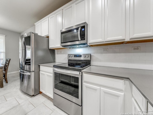 kitchen featuring white cabinets, light tile patterned flooring, backsplash, and stainless steel appliances