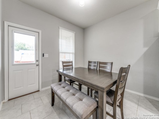 dining space featuring light tile patterned floors and baseboards